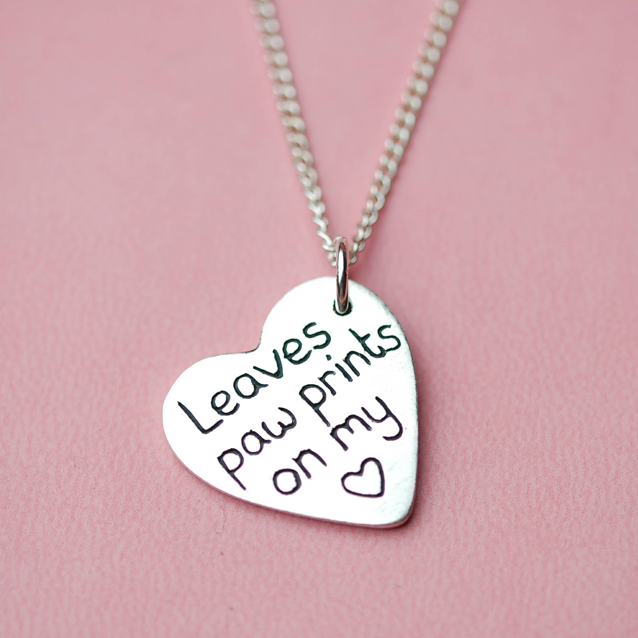 Inscription on the back of a silver heart paw print charm