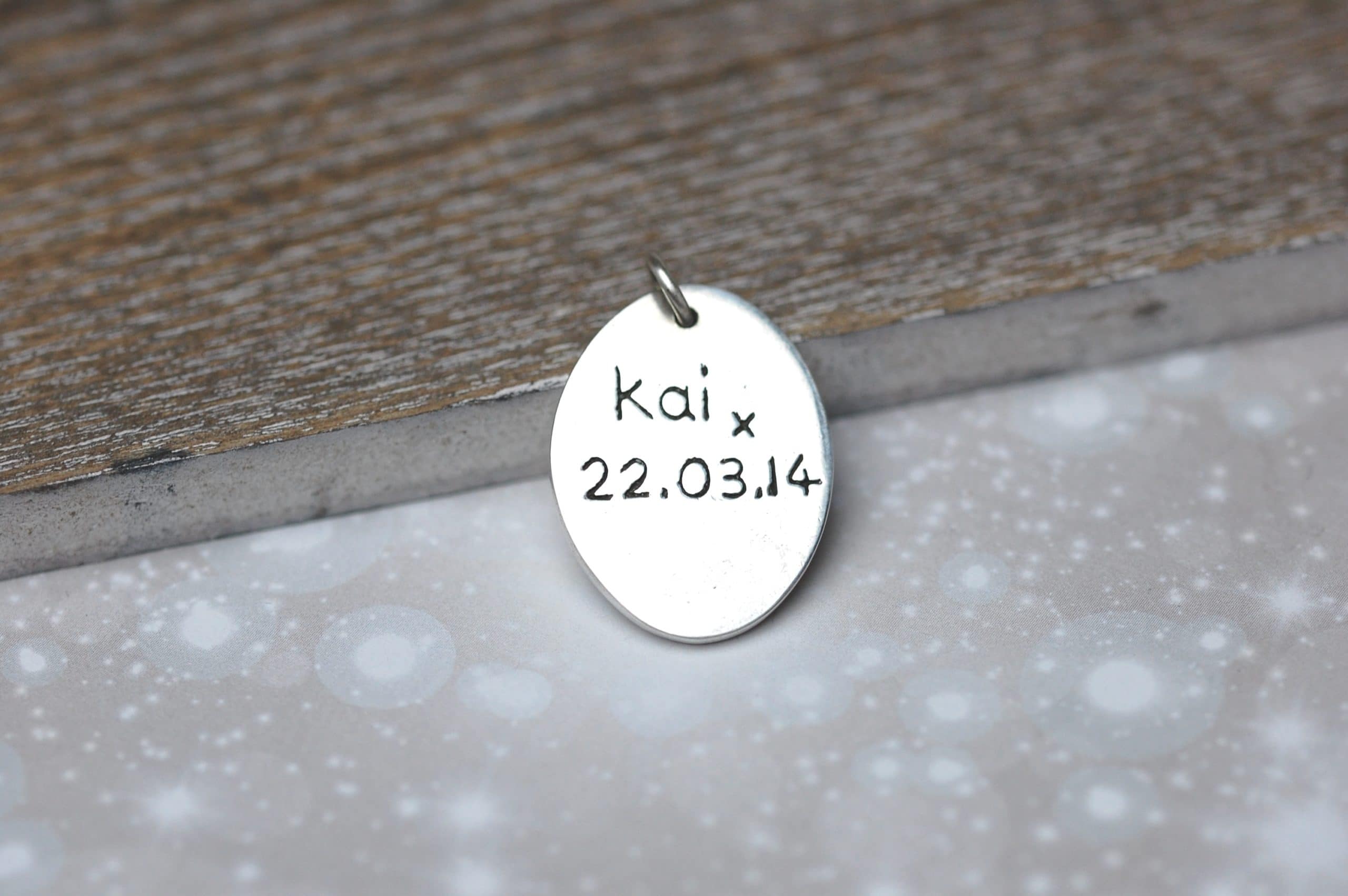 Inscription on the back of a silver oval paw print charm