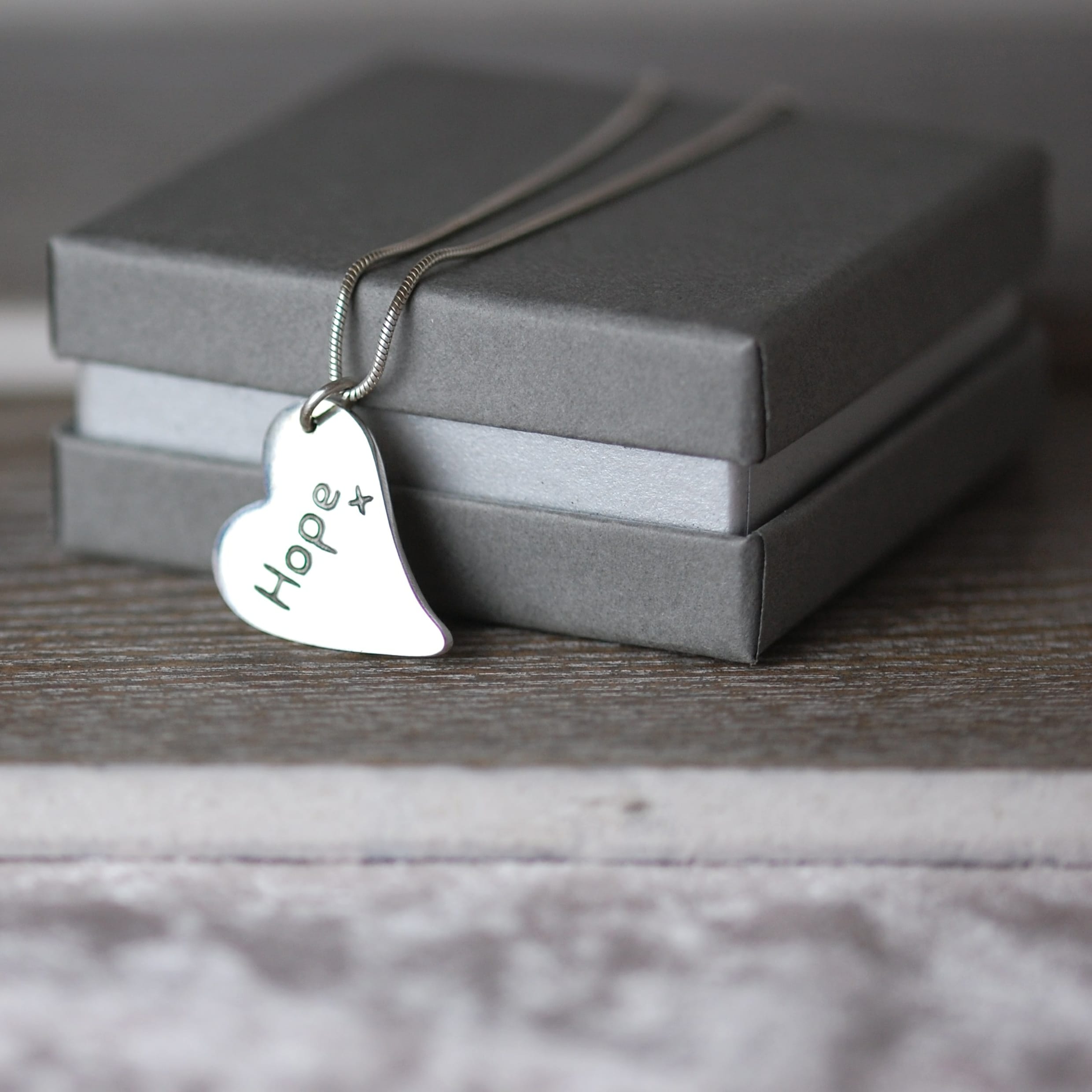 Inscription on the back of a silver curved heart paw print charm