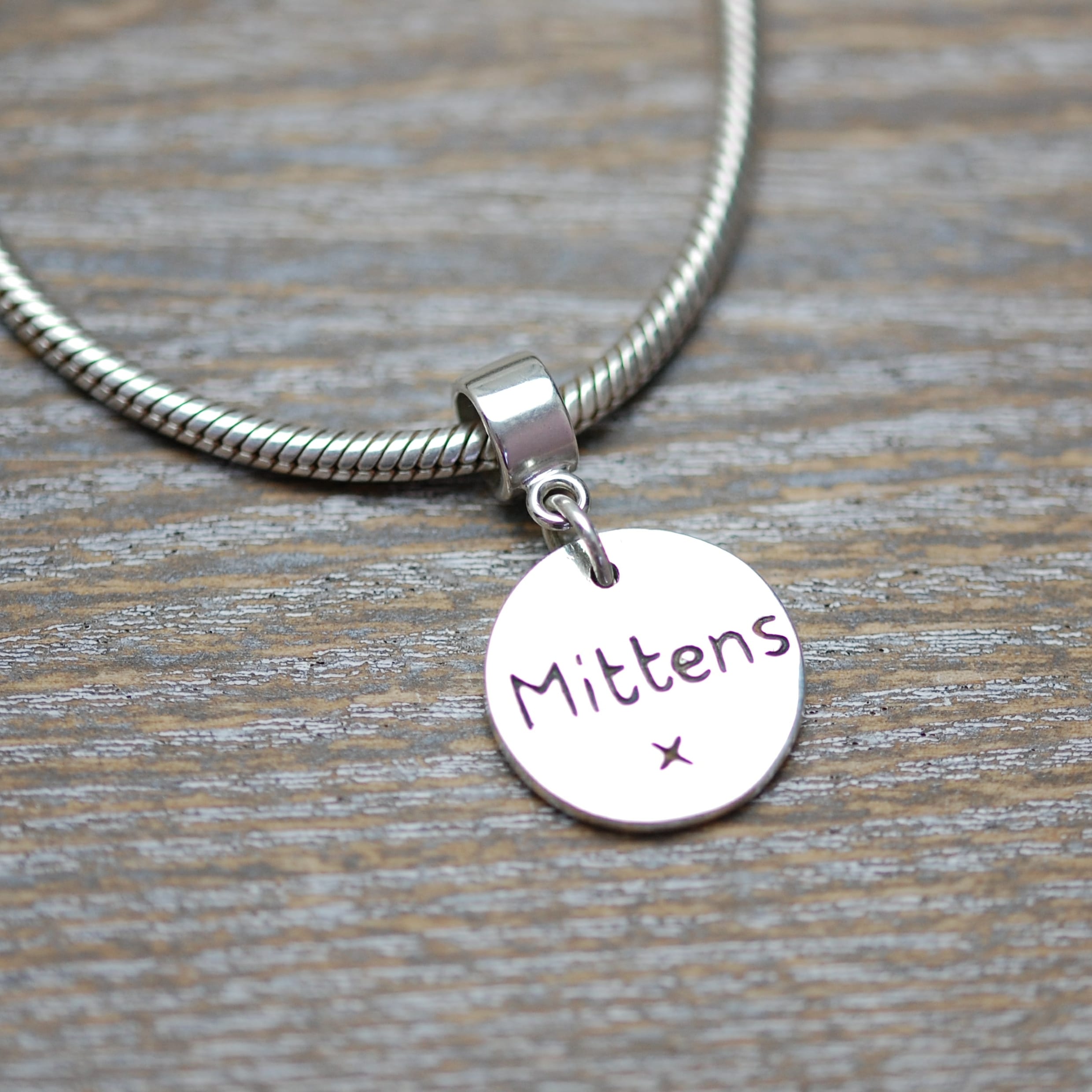 Inscription on the back of silver paw print charm