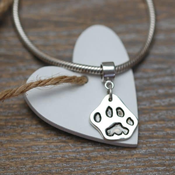 Small silver cut out paw print jewellery charm with charm carrier
