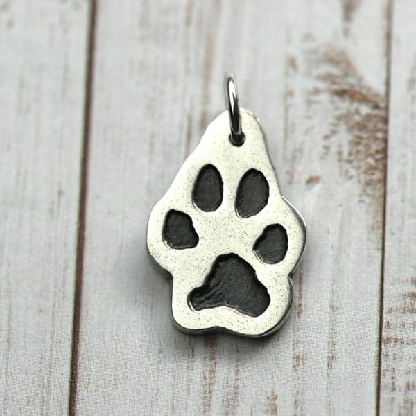 Silver charm cut out in the shape of your pet's unique paw print