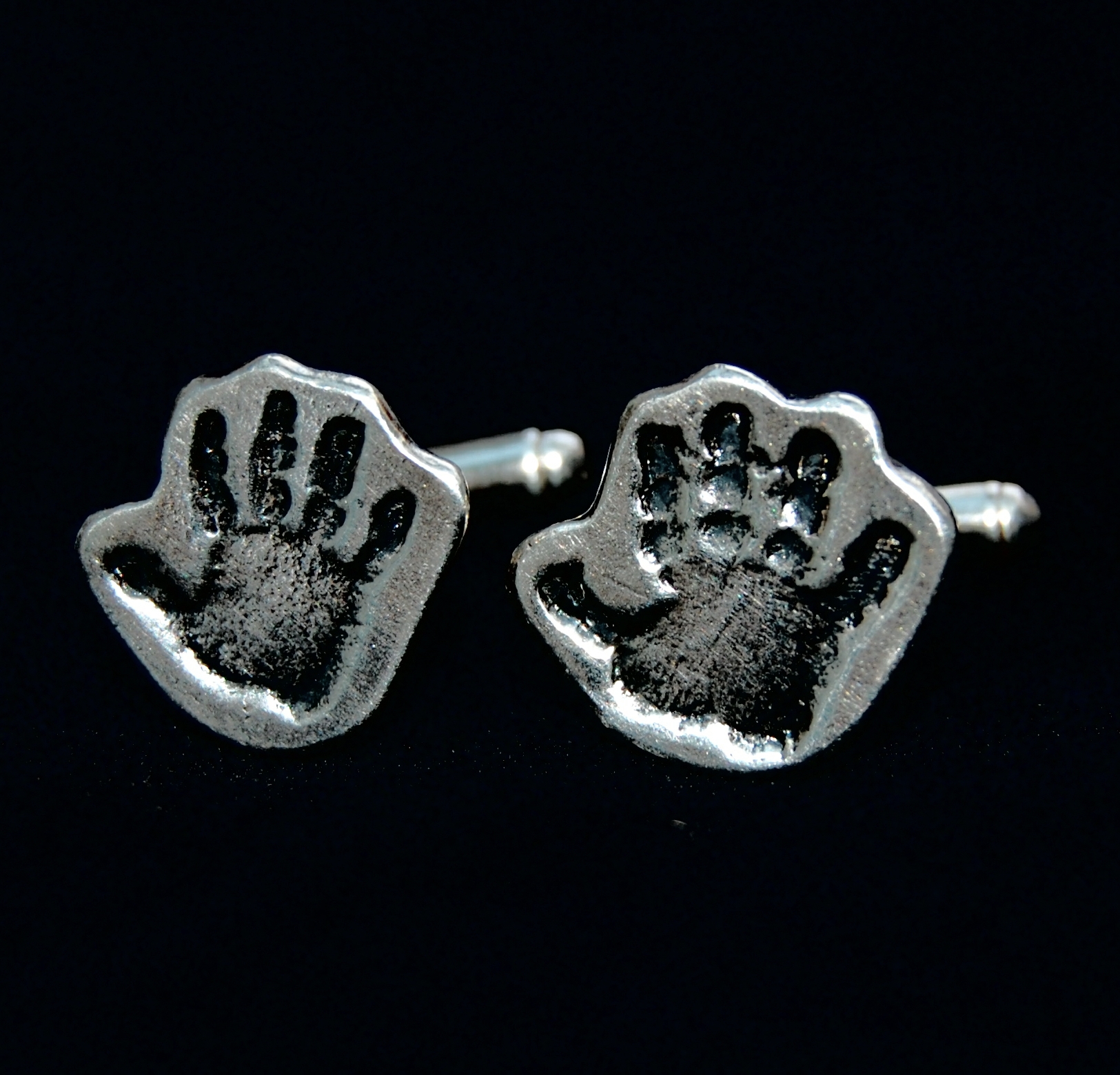 Silver cufflinks cut by hand in the shape of the handprints. Initials hand inscribed on the back.