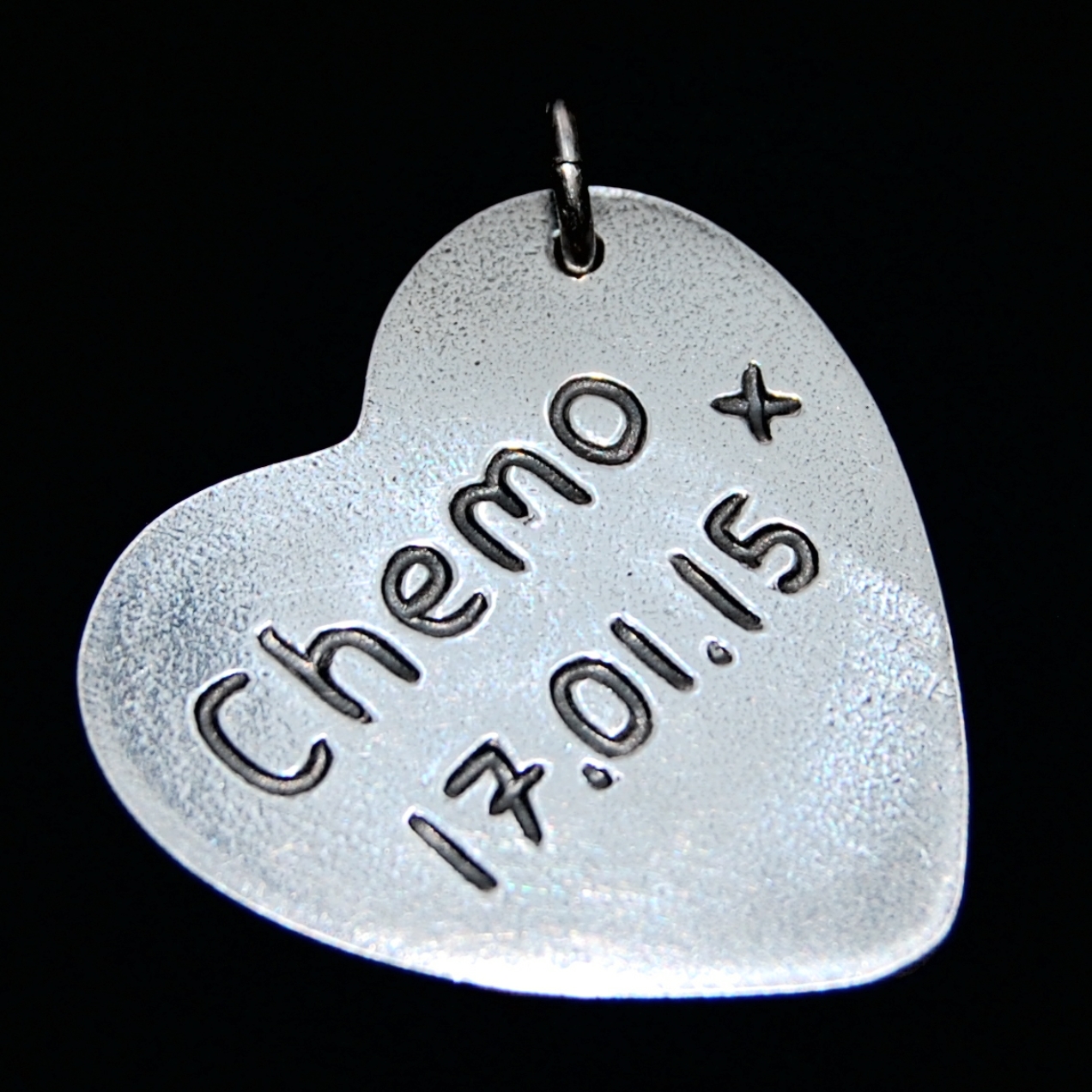 Name and special date inscribed on the back of a large heart charm.