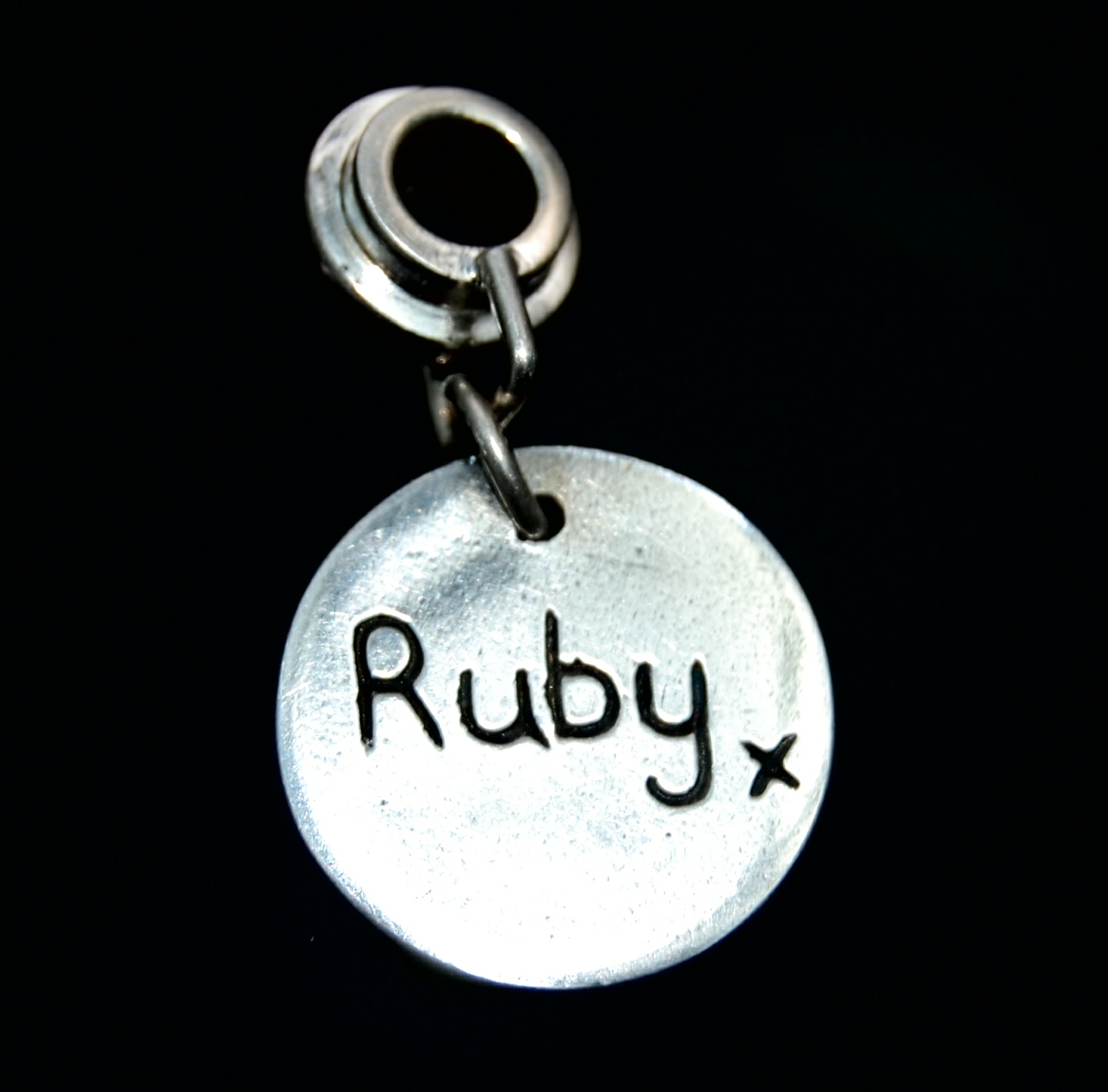 Small silver circle 'say it in silver' charm with name hand inscribed.