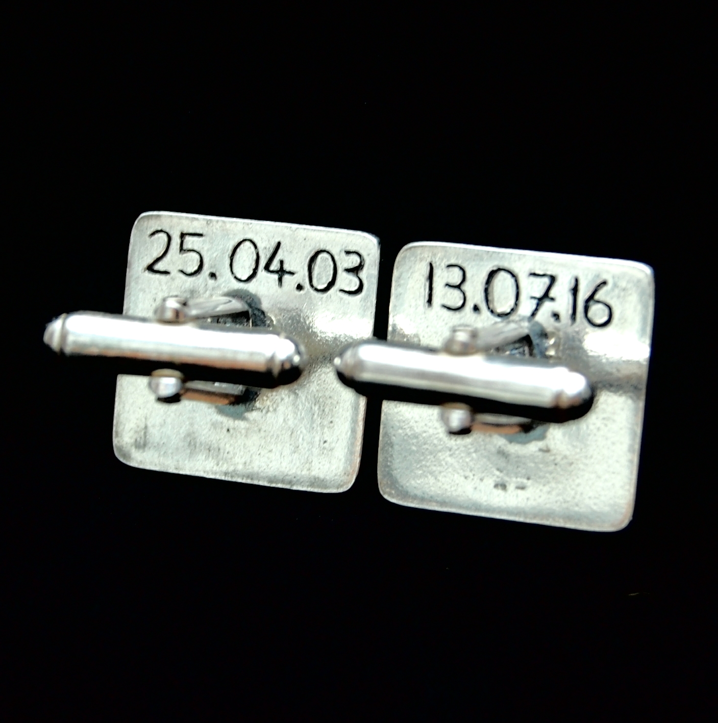 Dates inscribed on the back of square cufflinks.