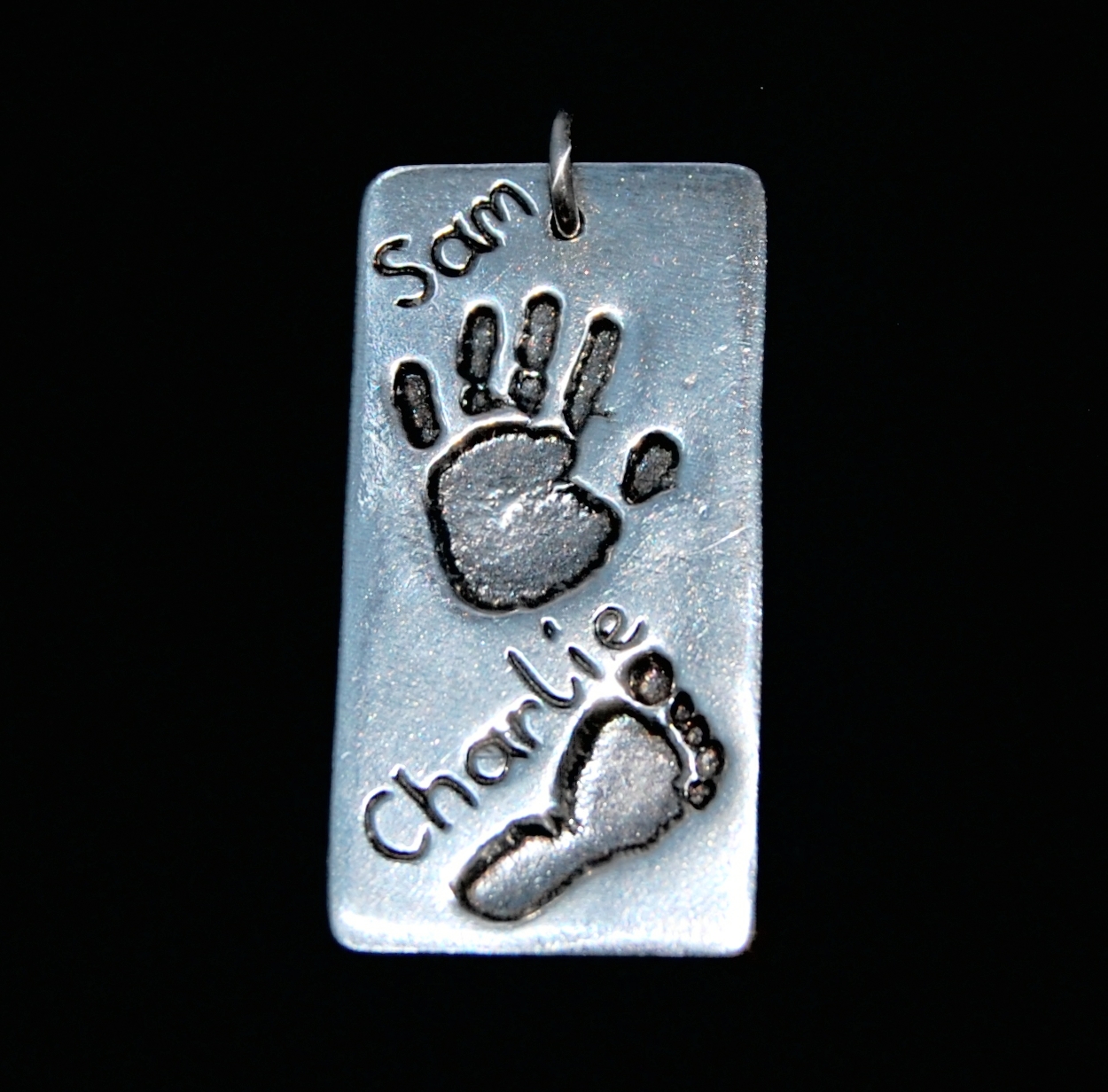 Large silver rectangle hand & footprint charm with names hand inscribed alongside the prints.