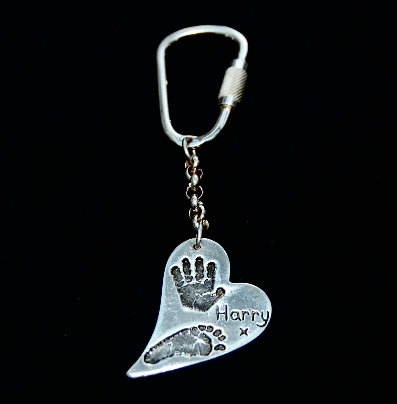 Large silver curved heart hand and footprint kering. Name hand inscribed alongside the prints.