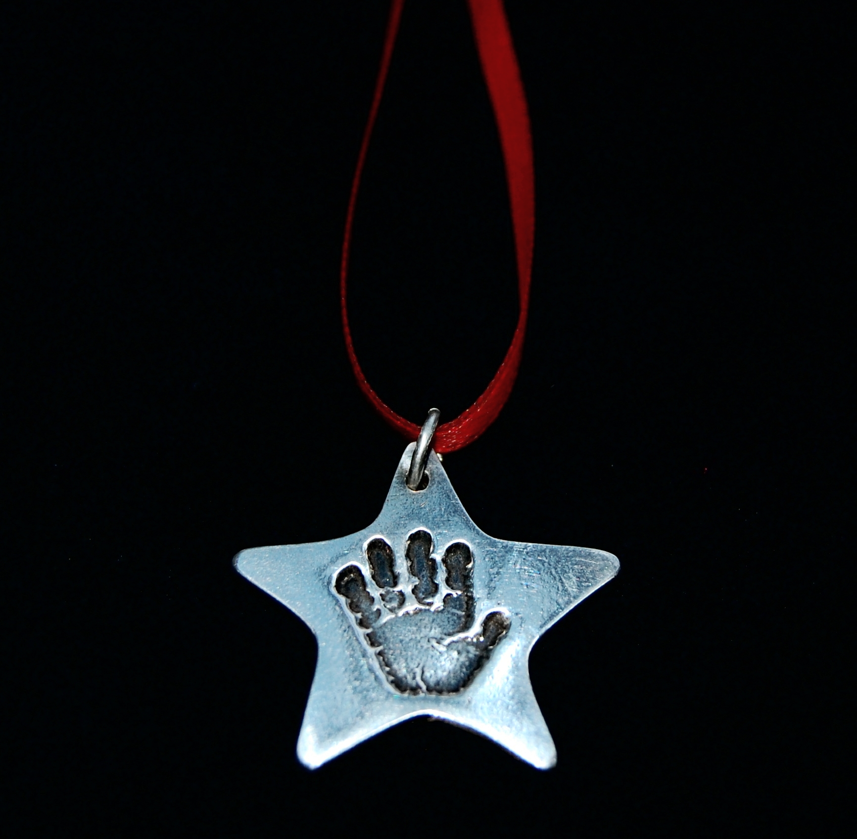 Regular silver star handprint charm with gorgeous red ribbon ready to hand in pride of place on your Christmas tree.