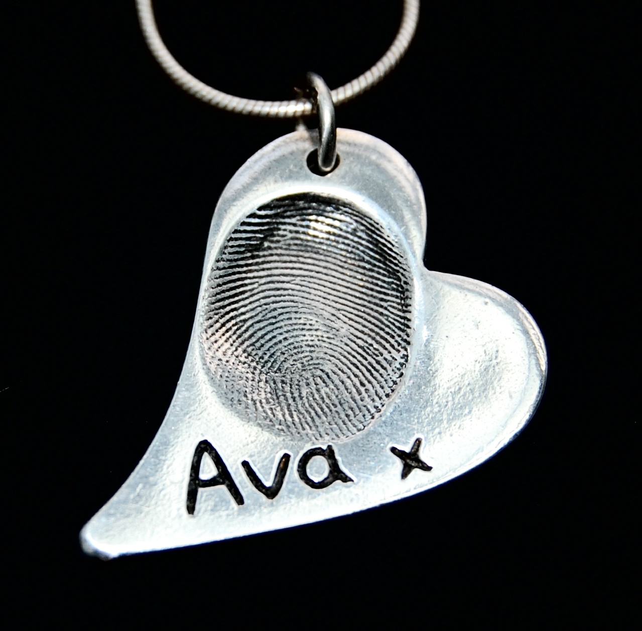 Regular curved heart shaped silver fingerprint charm with name inscribed alongside the fingerprint.