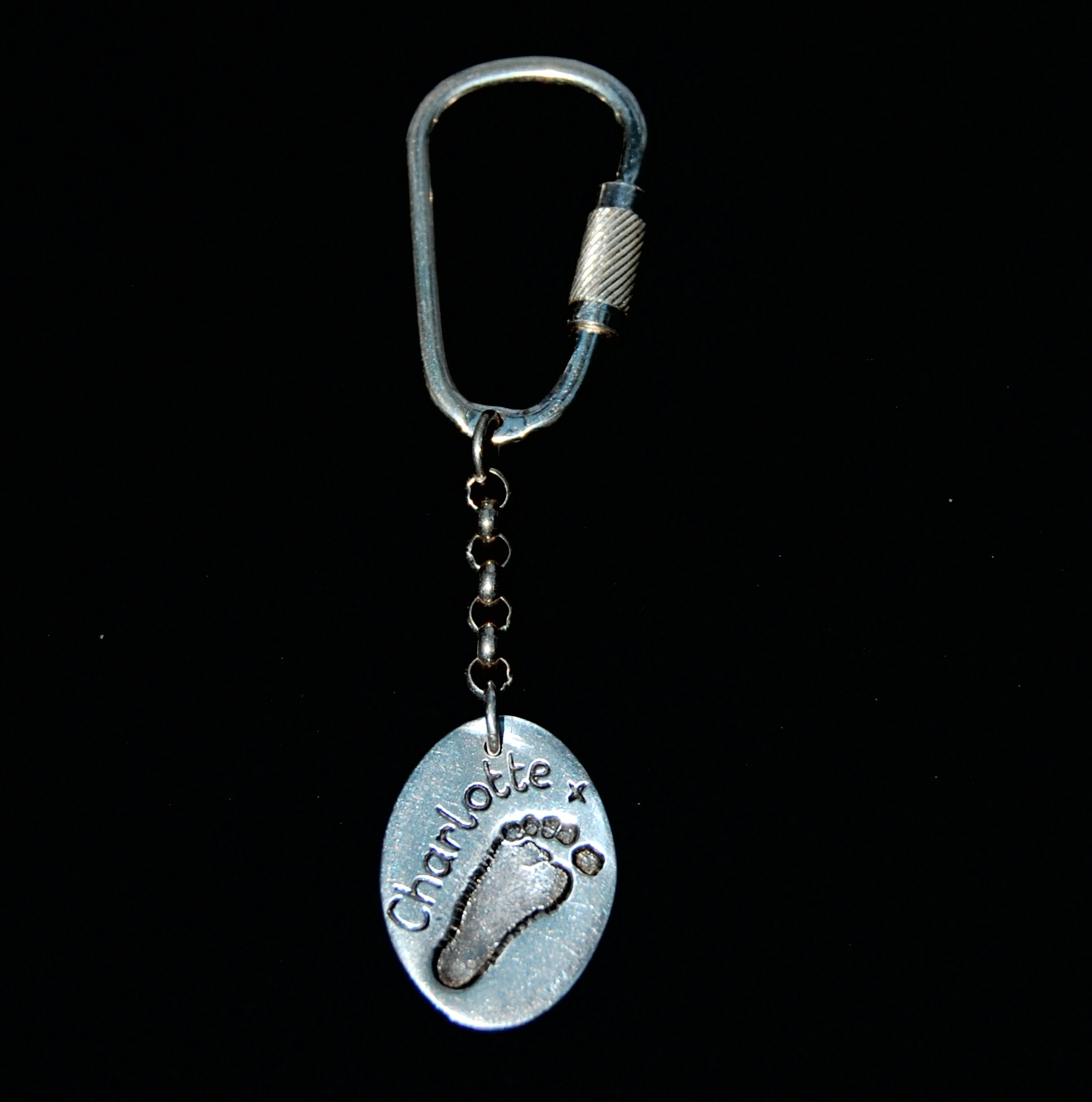 Regular silver oval footprint keyring personalised with name on the front.