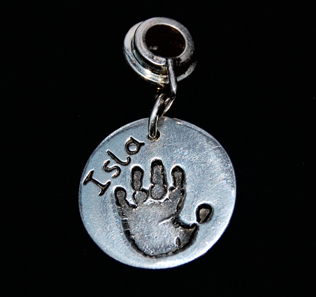 Regular silver circle handprint charm presented on a charm carrier.