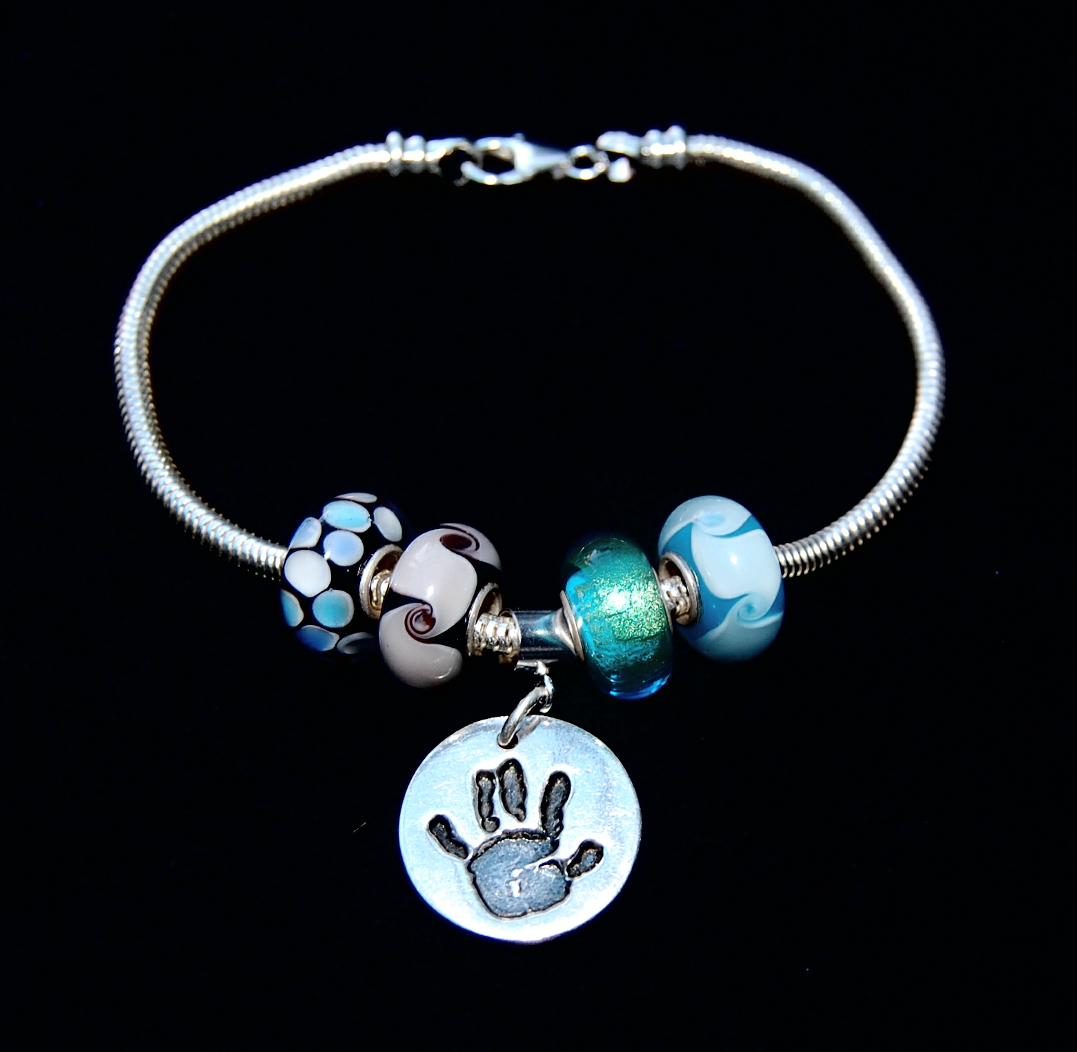 Small silver circle handprint charm with Pandora style charm carrier. Pandora style bracelet can be purchased separately.