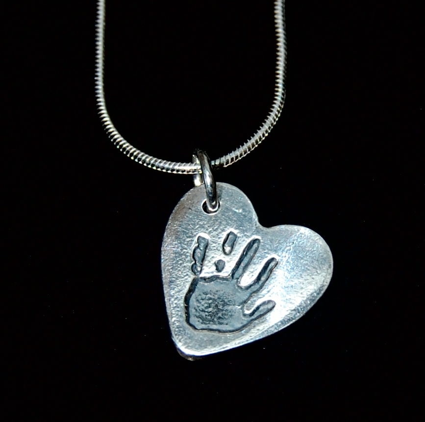 Small silver heart handprint charm on a sterling silver snake chain. Name hand inscribed on the back.