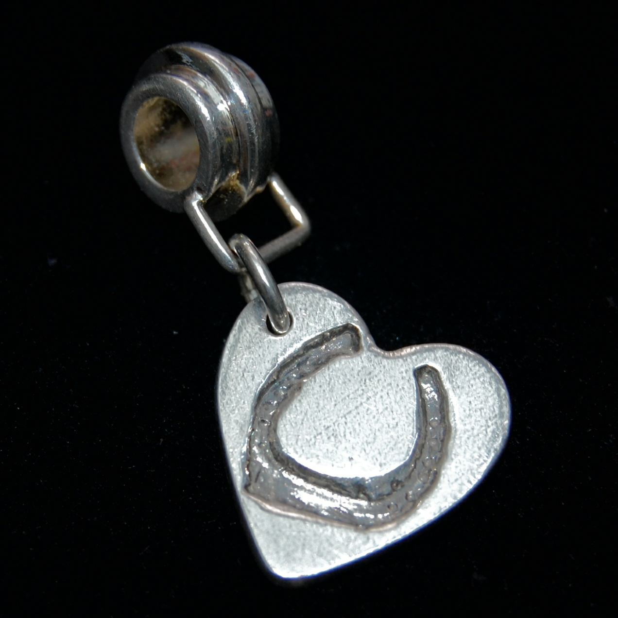 Small silver heart charm with your horse's shoe imprint. Presented on a charm carrier ready to add to your bracelet.