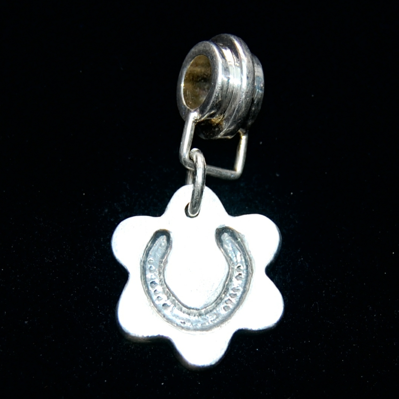 Small silver flower charm with your horse's shoe imprint. Securely attached to a charm carrier ready to add to your bracelet.