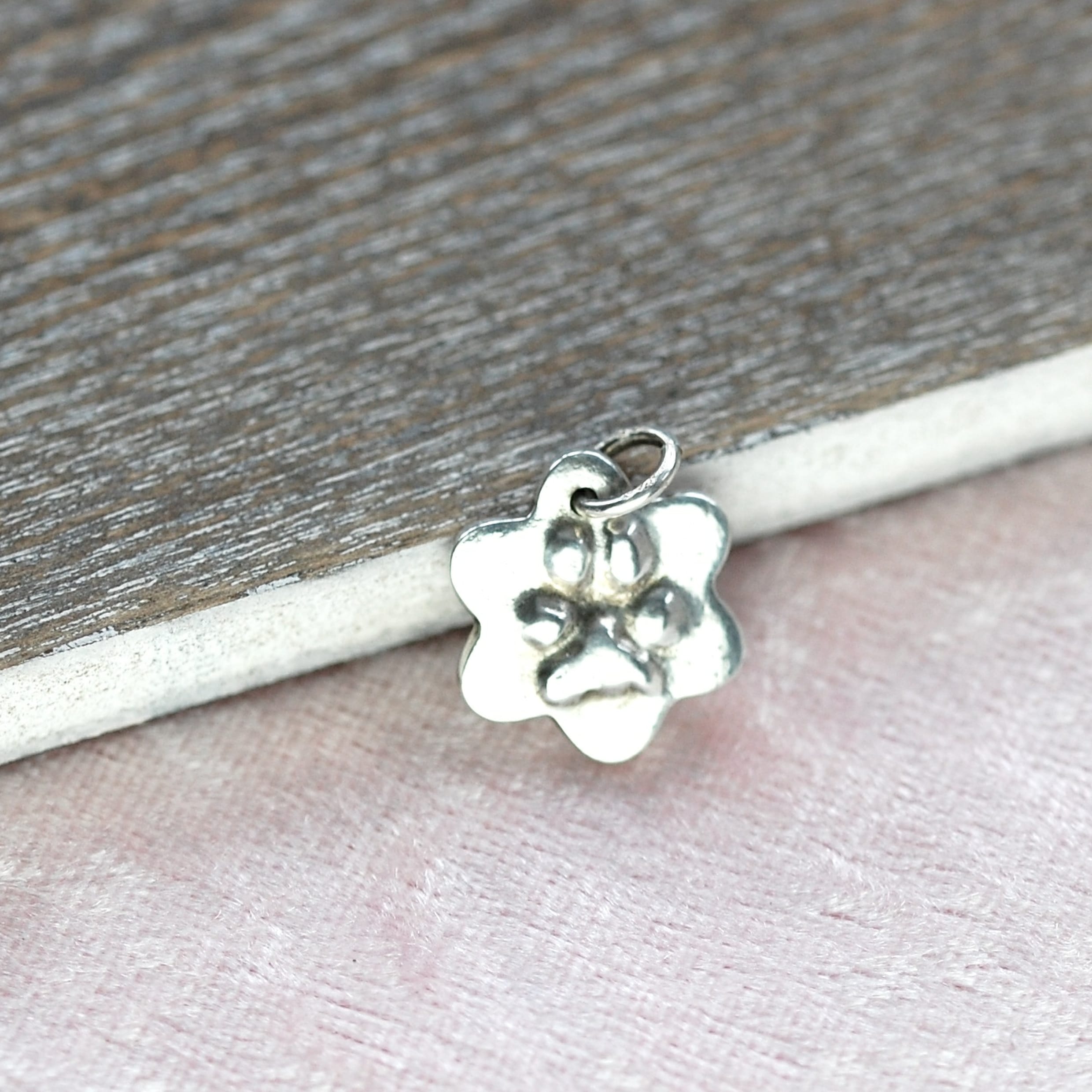 Smal silver flower charm with raised paw print