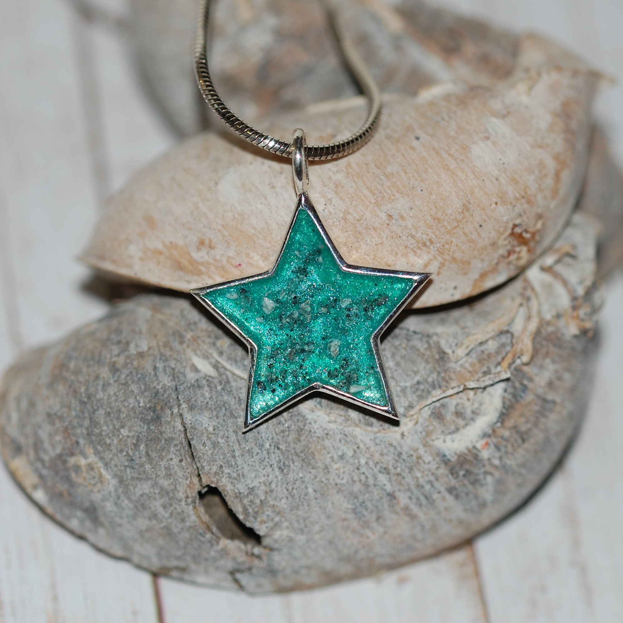Silver star pendant with pet cremation ashes and teal colour