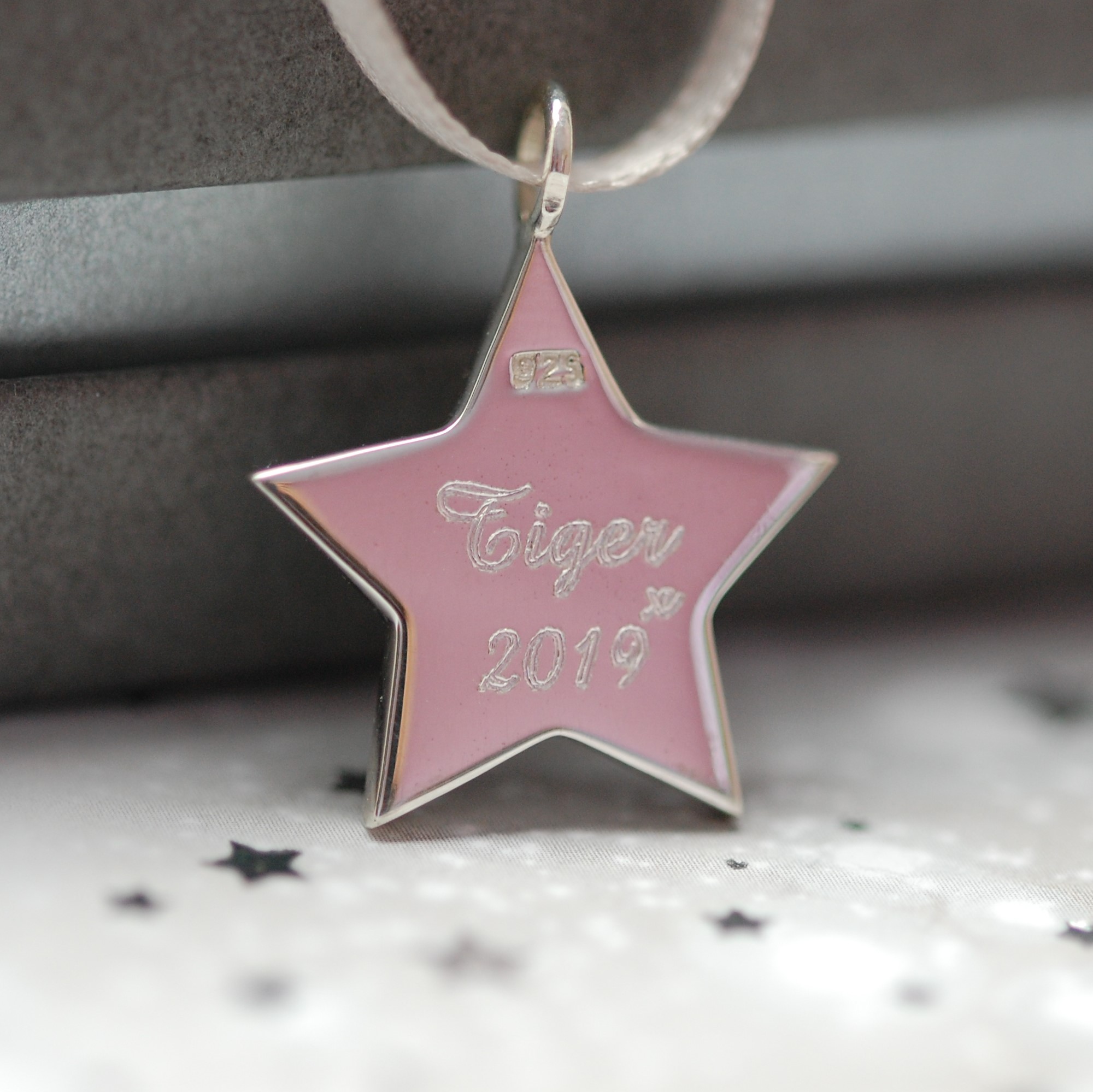 Pet name engraved on the back of sterling silver star with pet cremation ashes