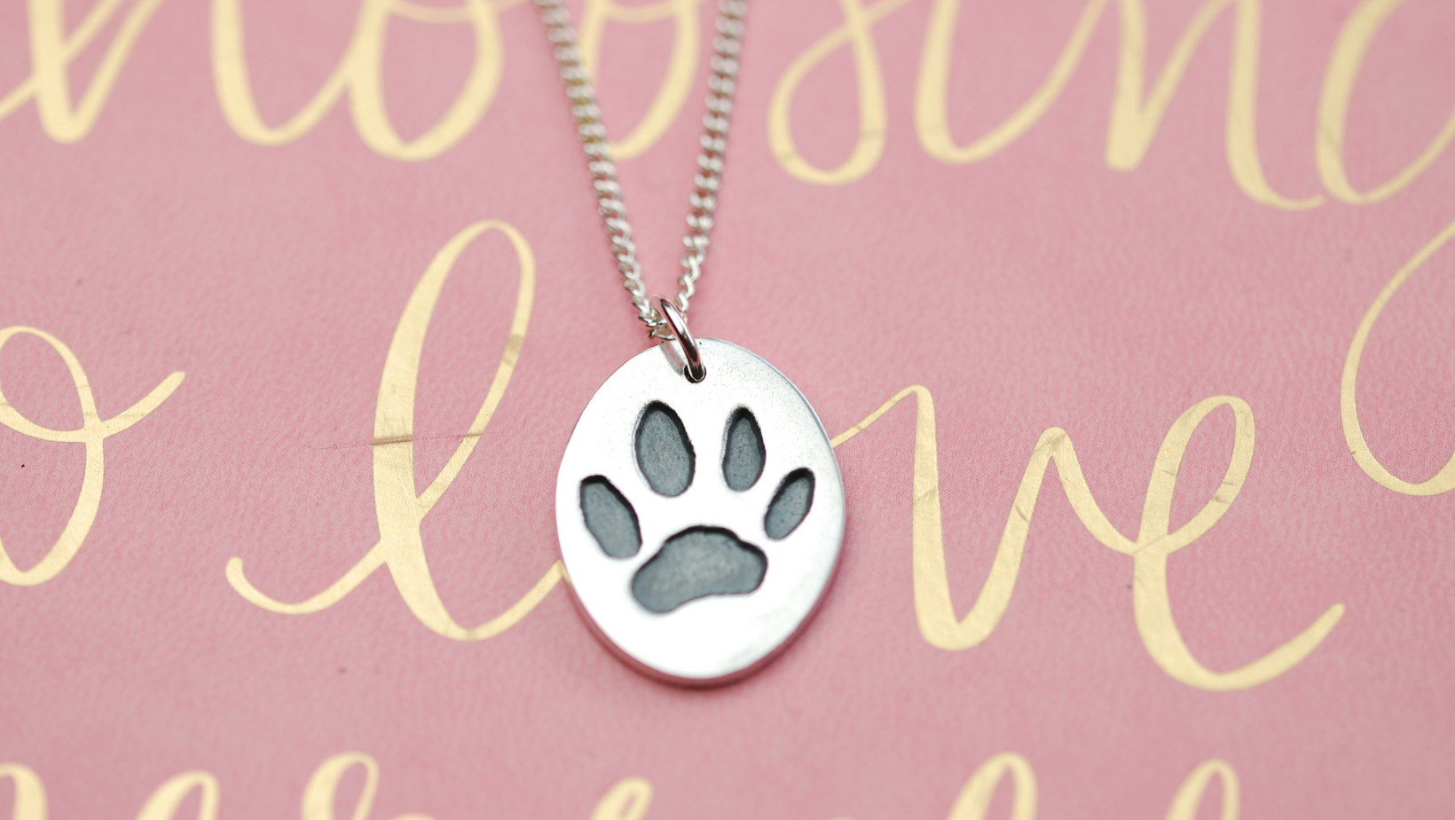 silver paw print charm with the word love